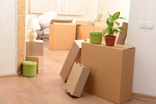 Trained movers using PPE while lifting furniture for a Putney move
