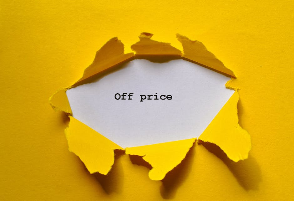 A hole torn in a bright yellow piece of paper reveals a white paper underneath with the words 'Off price' printed in black, positioned on a matching yellow background. The torn edges of the yellow paper are uneven and jagged, creating a textured appearance around the opening. In the context of home relocation and furniture transport, this image can symbolize discounted or reduced costs for services such as removals or packing, highlighting affordability. The scene is well-lit, with shadows cast by the torn paper edges adding depth. This visual suggests a focus on cost-effective solutions in the house removals process, possibly indicating promotional offers from Putney Man and Van for relocation services, including furniture removals and packing. The image's clean, simple composition emphasizes the message of affordability within the broader scope of professional moving and packing logistics.